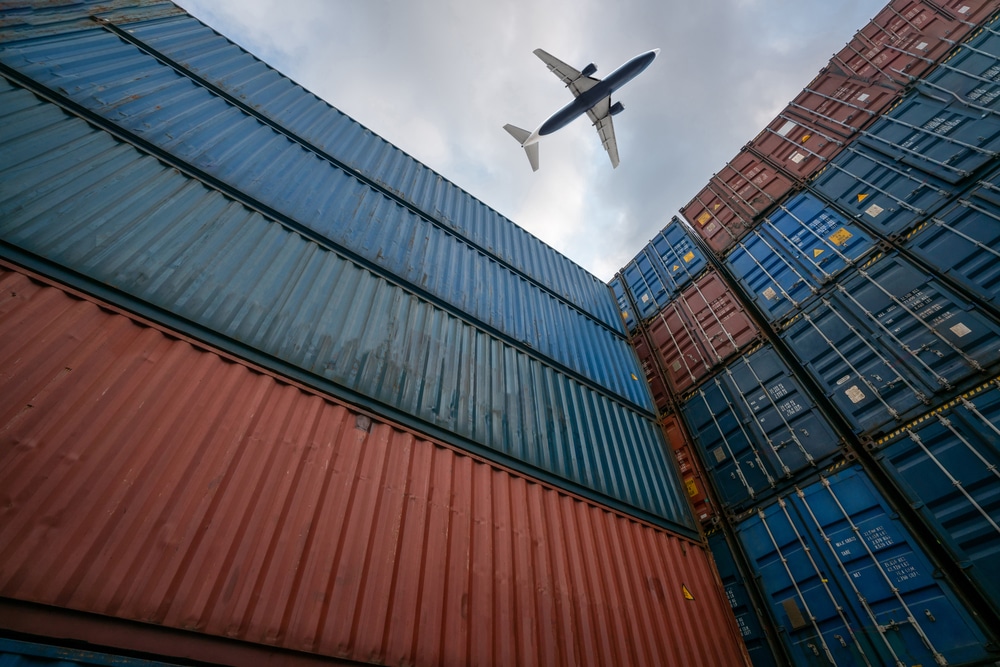 Cargo containers and airplane in sky